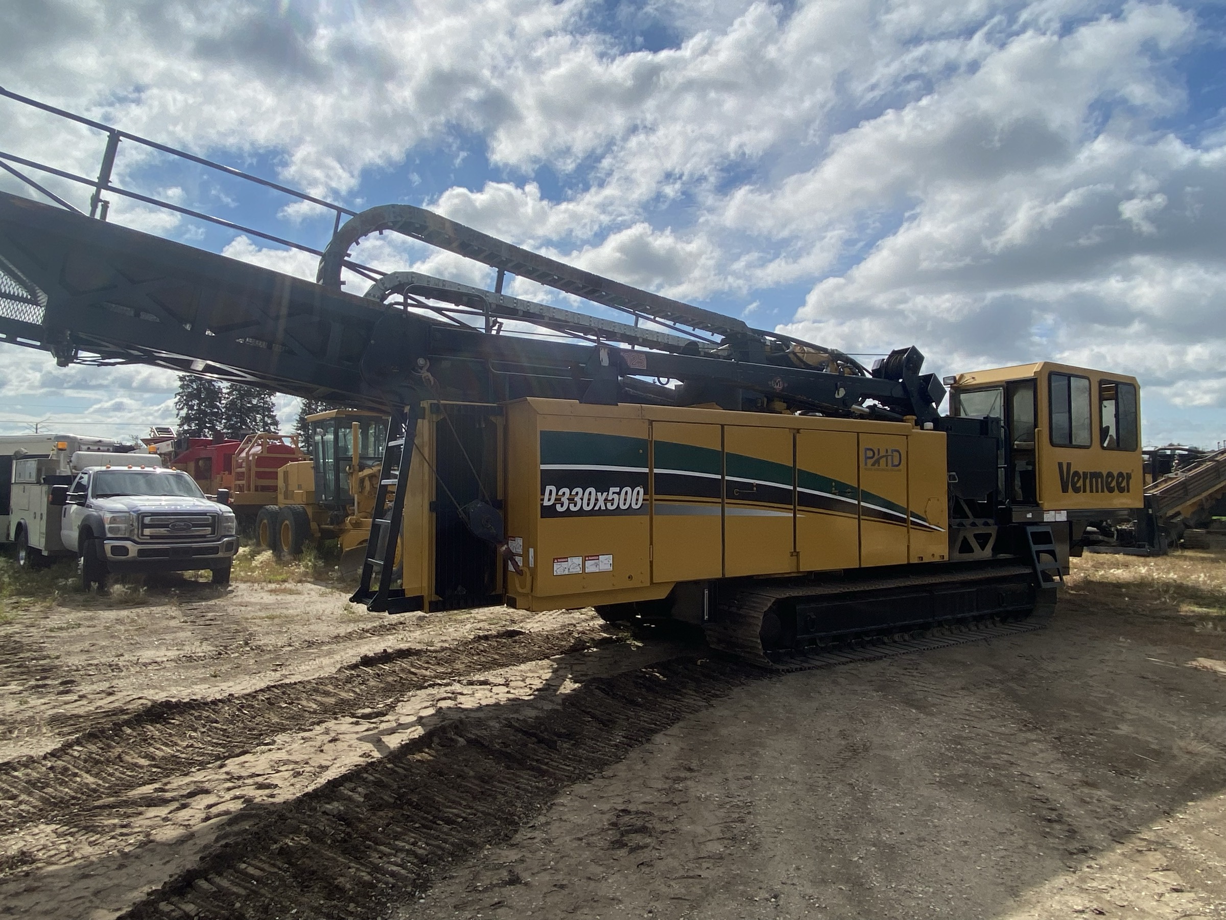 A Vermeer D330x500 directional drill in a yard, drill frame lowered, side view